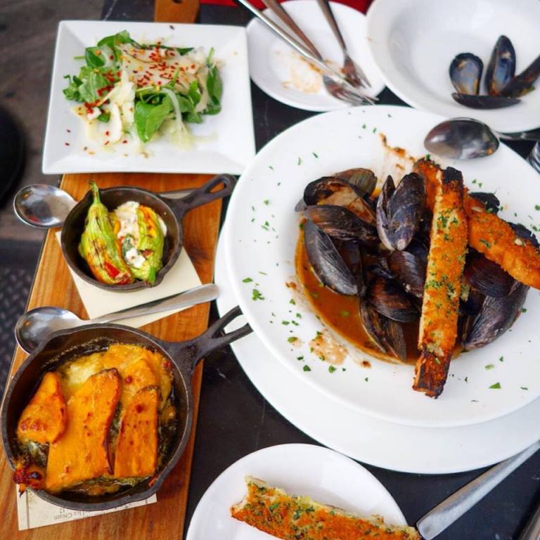 The Marshal – From bottom left, up to top left and then to the right - Satur Farms Sweet Potato & Kale Au Gratin, Phillips Farm Zucchini Blossoms stuffed with Tonjes Farm Ricotta, mozzarella, & “Farm”-esan, Dagele Bros Farm Tomato, Eckerton Hill Farm Basil, Fennel & Arugula Salad Dagele Bros sun chokes, chili flakes, “Farm”-esan cheese, Upstate verjus dressing and Wood Oven Roasted Maine Mussels - Winter Sun Farms tomato, butter, Spring garlic, Finger Lakes white wine, herbs & wood oven breadsticks