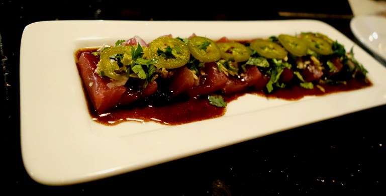 Desnuda NYC – Tiradito de Atun – Yellow fin tuna in a savory shishito -yuzu-truffle glaze, pickled jalapeños, red onion and potato chip crunch