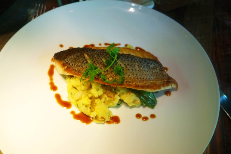 Urbo Kitchens, Urbo - Times Square - Pan Roasted Striped Bass with crushed butterball potatoes, grilled scallions & truffle butter 
