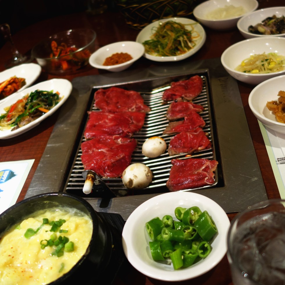 So Moon Nan Jip – Korean BBQ - Palisades Park NJ - Bulgogi just placed on the grill, all of our sides and of course my fave - steamed egg. YUM