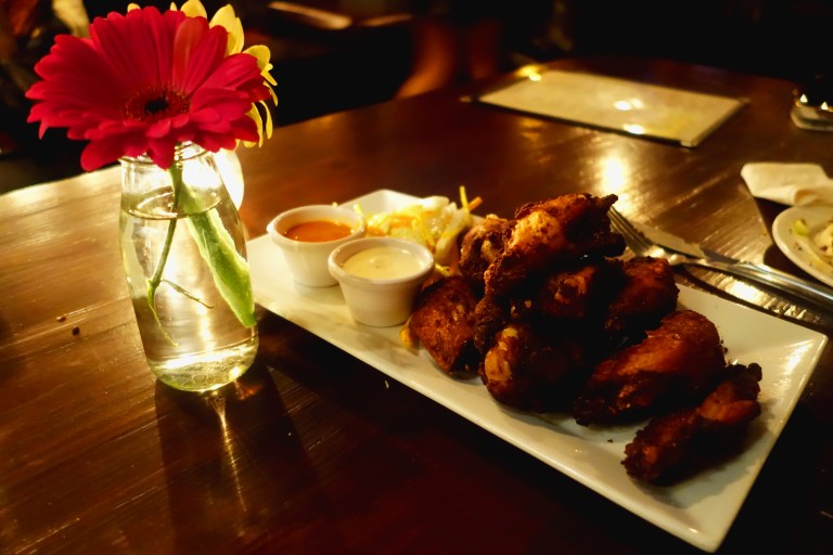 Tanner Smiths – Midtown NYC - Dry rubbed crispy chicken wings with blue cheese & buffalo sauces on the side with a celery jicama salad.