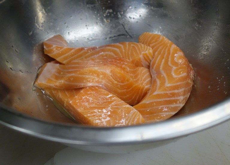 Salmon marinates in olive oil, chopped garlic -which they soak for days in olive oil, and kosher salt.