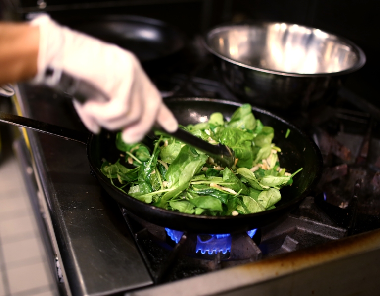 Adding fresh spinach to the caramelized fennel.
