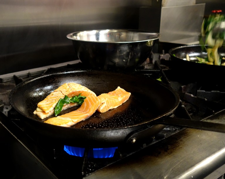 The split salmon is placed in a warm pan and filled one by one.