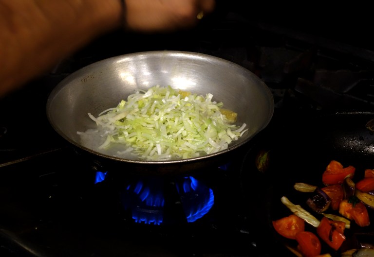 The leeks are then sautéed in a pan with garlic.